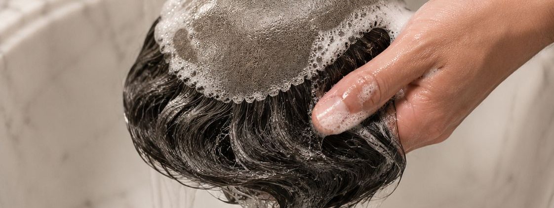 Hair system being gently washed at the basin